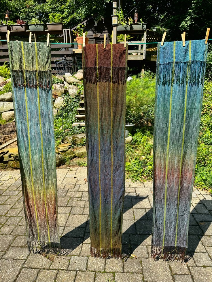 Three handwoven scarves drying