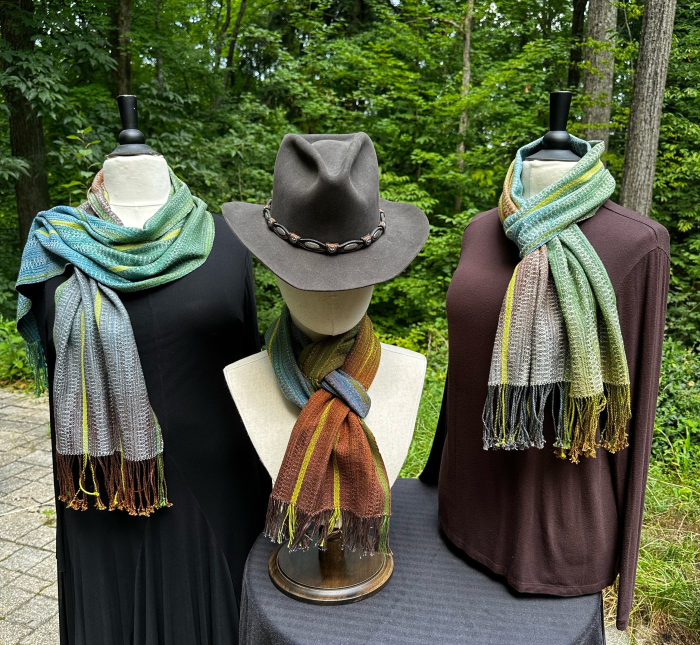 Three mannequins with hand woven scarves
